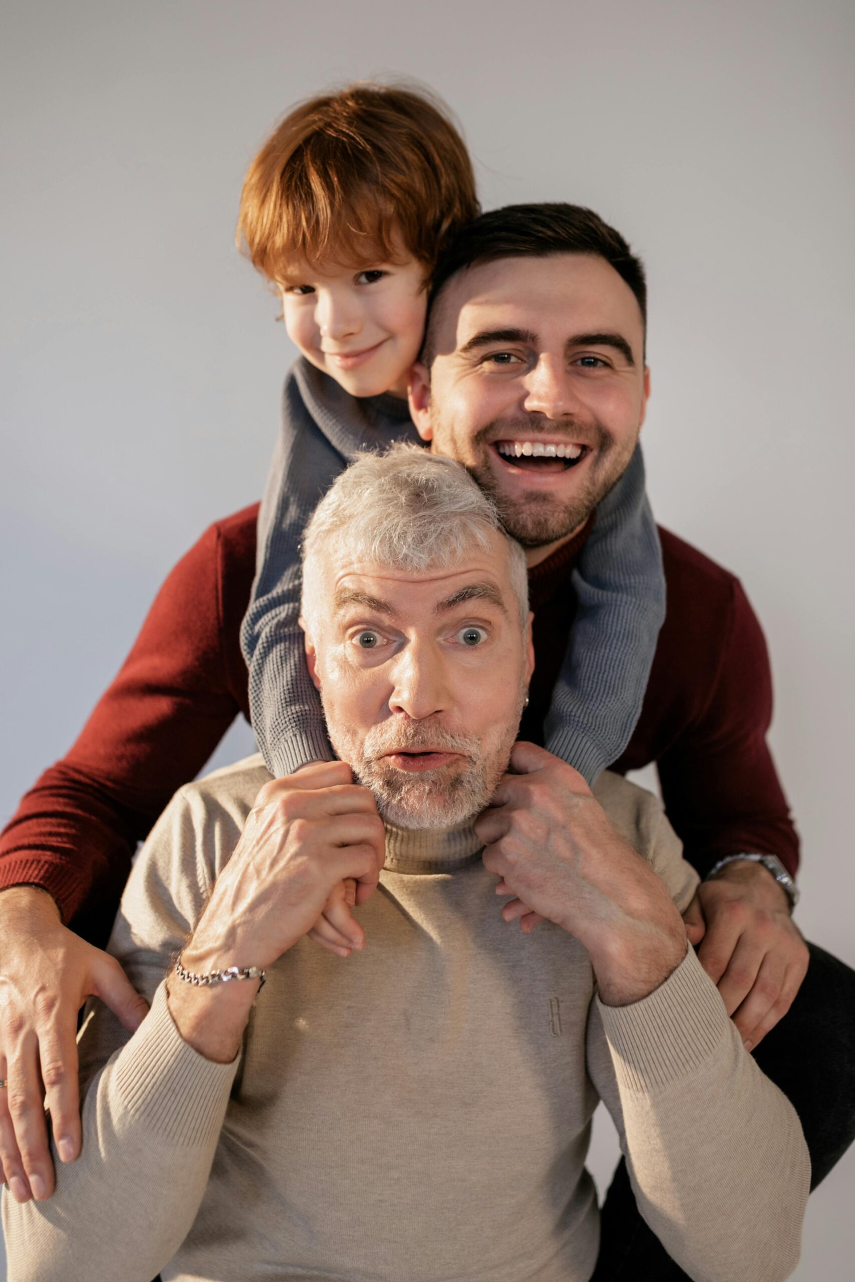 A joyful moment captured with a grandfather, father, and son showing happiness and bonding.